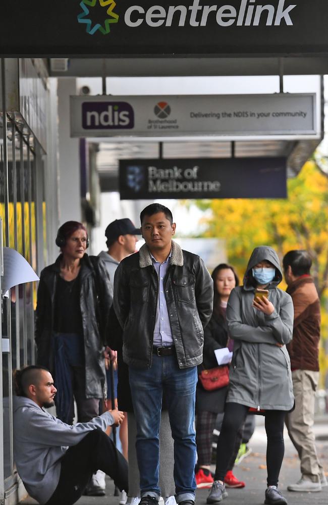 People queue up outside a Centrelink office in Melbourne in April during the pandemic which will hit young Aussies hard. Picture: William WEST / AFP