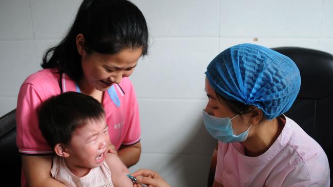 (FILES) This file photo taken on July 24, 2018 shows a child receiving a vaccination shot at the local disease control and prevention center in Jiujiang in China's central Jiangxi province. - China's Communist Party has sacked a dozen provincial and local officials and vowed to punish a pharmaceutical firm over a vaccine scandal that inflamed public fears over the safety of domestically produced drugs. The first political casualties fell on August 16, 2018 as a dozen officials were removed from office. (Photo by STR / AFP) / China OUT