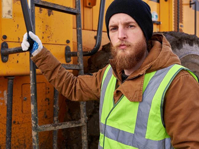 CAREERS: mining worker. Picture: iStockWaist up portrait of bearded worker posing with heavy yellow truck and  looking at camera, copy space