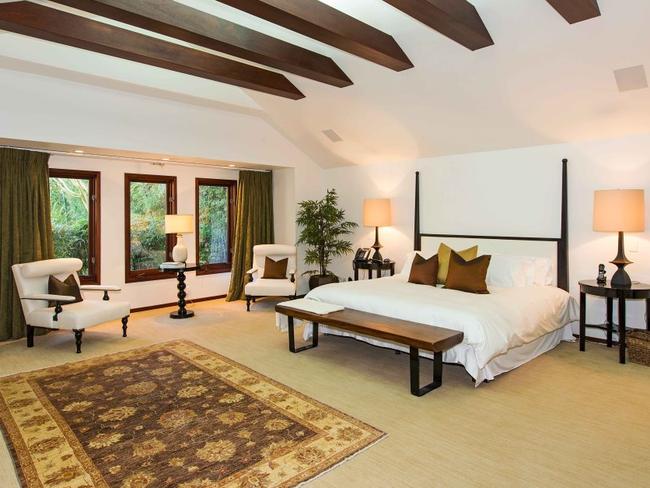 The master bedroom features a high ceiling complete with dark wood beams.