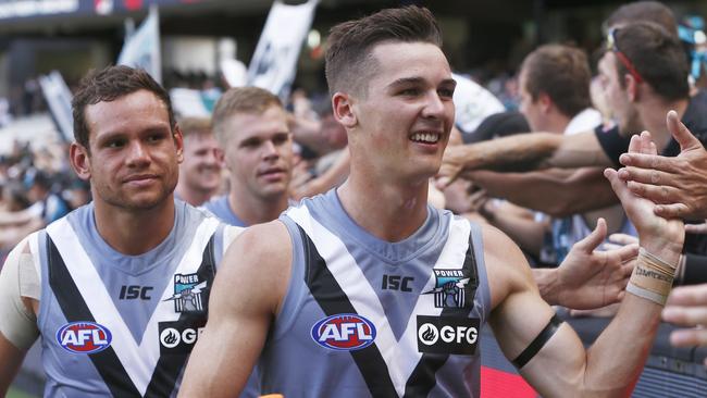 Steven Motlop of the Power (left) and Connor Rozee of the Power greet fans after the Round 1 AFL match between the Melbourne Demons and the Port Adelaide Power at the MCG in Melbourne, Saturday, March 23, 2019. (AAP Image/Daniel Pockett) NO ARCHIVING, EDITORIAL USE ONLY