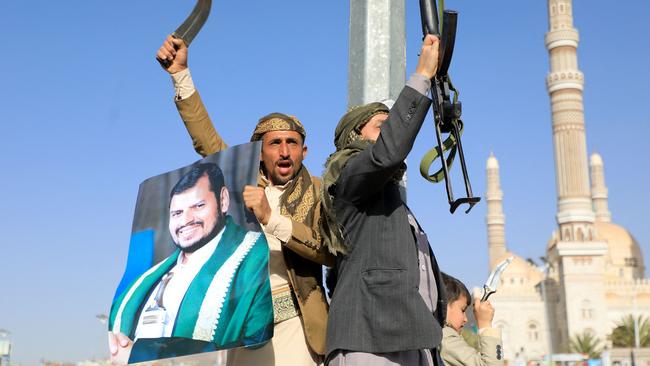 Protesters, one holding a portrait of Houthi leader Abdul Malik al-Houthi (L), brally against the US and UK in the Houthi-controlled capital Sanaa. Picture:  AFP.