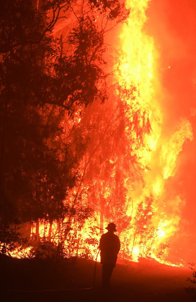 RFS, NSW Fire and Rescue and NPWS officers joined residents to fight a bushfire encroaching on properties near Termeil on the Princes Highway between Bateman’s Bay and Ulladulla south of Sydney on Tuesday. Picture: AAP/Dean Lewins