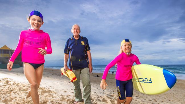 Southport Surf Club life member John Ogilvie with nippers Imogen Coman, 10 and Dean Olsen, 11 ahead of the club's 100-year anniversary celebrations this weekend. Picture: Nigel Hallett. Mr Ogilvie reflects: “Main Beach can be very treacherous. Back in the day, we only had the reel, line and belt to rescue people - there were no boards, rescue tubes, IRBs or helicopters.”