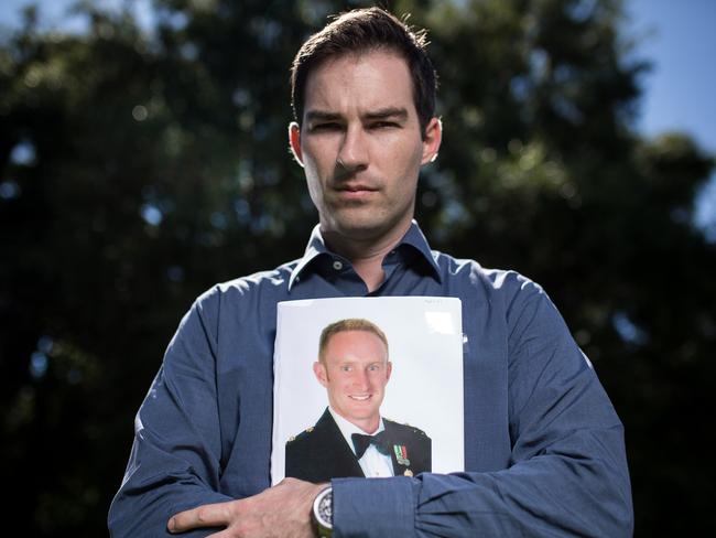 Afghanistan veteran John Bale holds a photo of his fallen friend Lt. Michael Fussell at Parliament House in Canberra. Picture: Stefan Postles