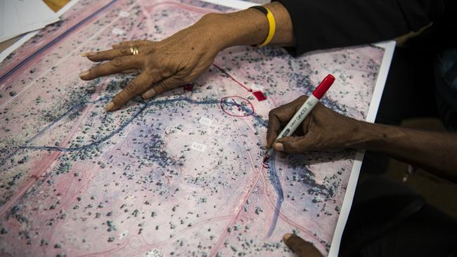 Local elders mark a satellite image of the block of land where the first three homes will be built. Picture: Andrew Quilty/Climate Council