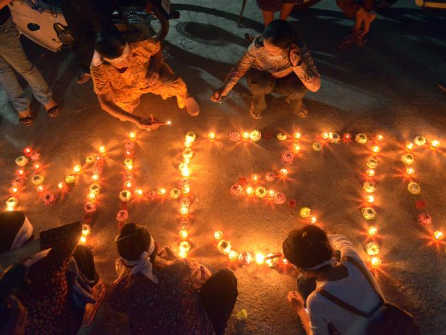 Cambodian residents light candles as they pray for the missing Malaysia Airlines flight MH370 in March 2014. Picture: AFP