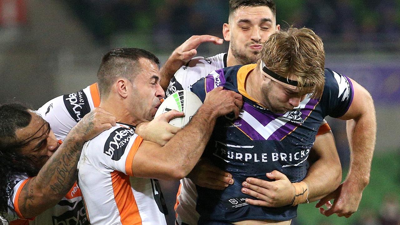 Christian Welch of the Storm (right) is tackled during the match between the Melbourne Storm and the Wests Tigers