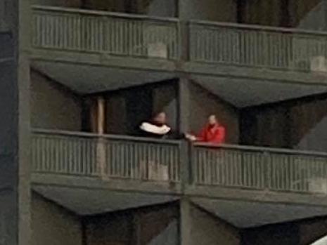 Guests share items between balconies at Brisbane’s Hotel Grand Chancellor on May 25.