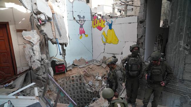 Israeli soldiers inspect the entrance to a reported tunnel, where the Israeli Army said Palestinian fighters killed six hostages, in Rafah in the Gaza Strip on Friday. This photo was taken under Israeli supervision. Picture: Sharon Aronowicz / AFP