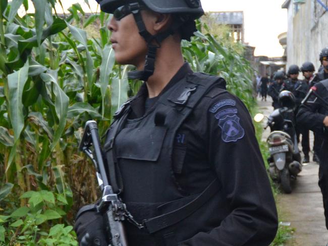 Indonesian police personnel patrol during a raid on the home of a terror suspect in which five people were arrested in Malang, East Java province, on February 20, 2016. Indonesian police said that they have arrested 41 suspected Islamic militants in two separate raids in Java island in the aftermath of attacks in Jakarta on January 14 that killed eight people, including four civilians. AFP PHOTO / Aman ROCHMAN