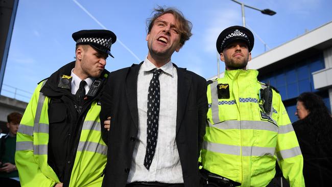 Police officers arrest an activist at London City Airport Picture: AFP