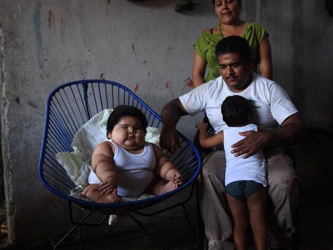 Ten-month-old Luis Gonzales with his parents Isabel Pantoja and Mario Gonzales, and his elder brother Mario at their home in Tecoman, Colima State, Mexico. Picture: AFP