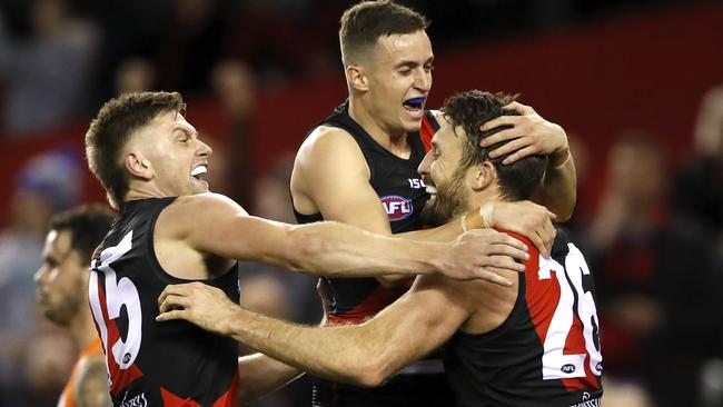 Cale Hooker celebrates his matchwinning goal with Orazio Fantasia and Jayden Laverde. Picture: Dylan Burns/AFL Photos.