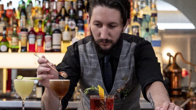 Jacob Wicks prepares cocktails, including the negroni, far right. Picture: Monique Harmer