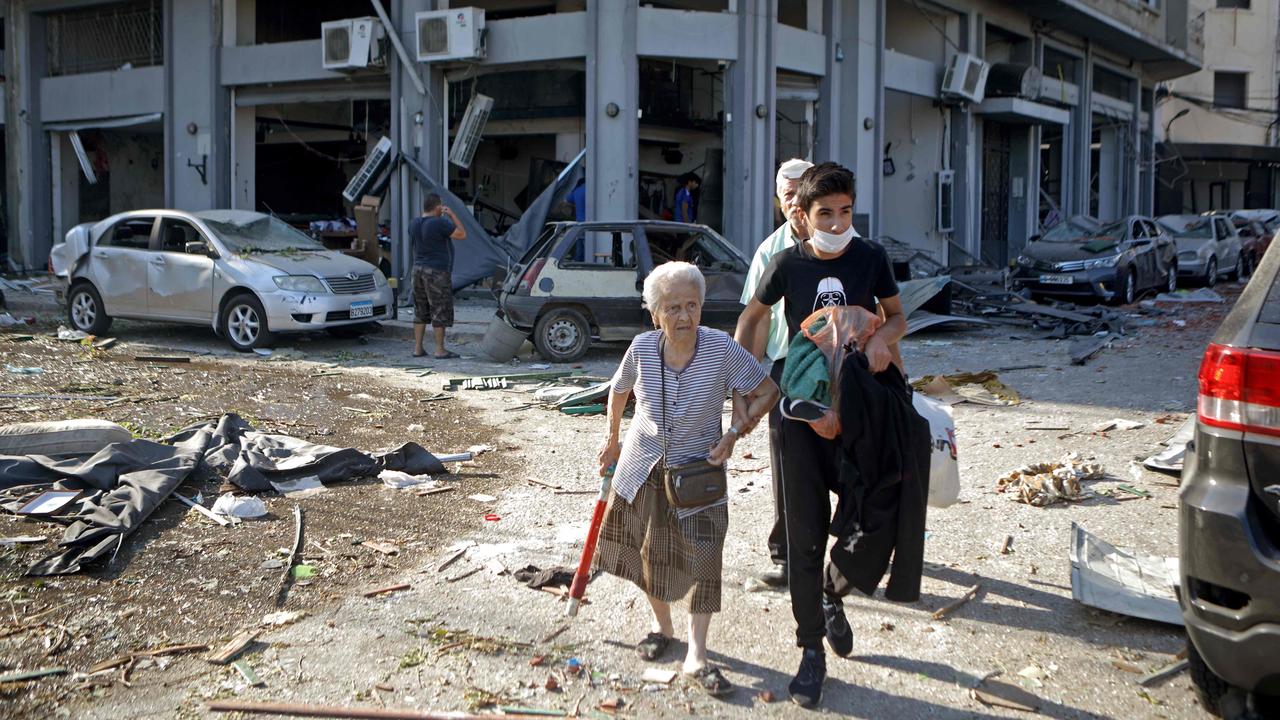 A woman is evacuated from the partially destroyed Beirut neighbourhood of Mar Mikhael. Picture: AFP