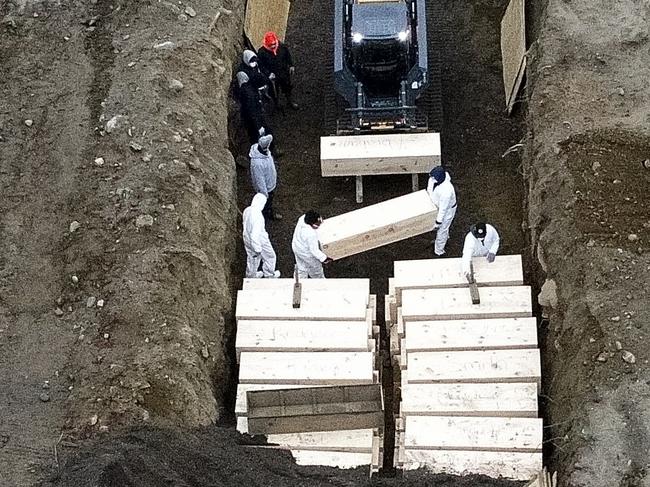 Workers bury bodies in a trench on Hart Island in the Bronx, New York. Picture: AP