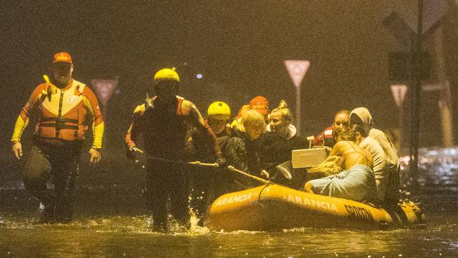 Carole Lloyd her grandson Dekota Davidson, Huana Cleaveland, Tia Grace and Malia Cleveland being evacuated by Surf Rescue from their home at Mactier St, Narrabeen, when Narrabeen Lagoon flooded in February, 2020. Picture: Damian Shaw