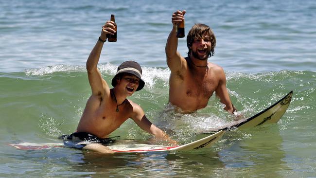 L-R Lucas Kubina and Moritz Hartmann of Germany enjoy a Christmas beer in the surf at Noosa Heads beach in 2002. Picture: John Wilson