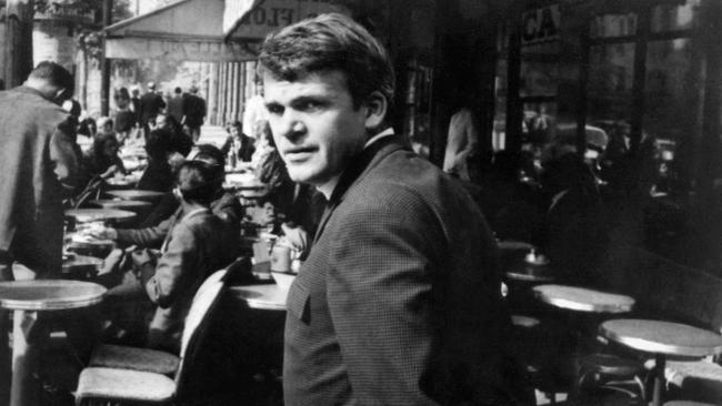 Czech writer Milan Kundera walks by a cafe in the centre of Paris in 1975.