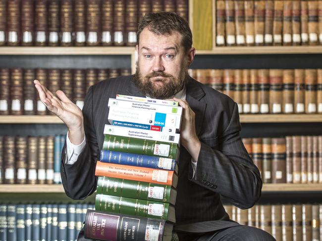 Cover photo for moneysavery HQ - tax expert Adrian Raftery with pile of books. Picture": Jason Edwards