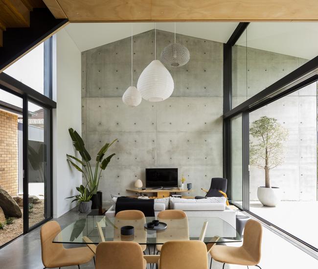 The double-height void makes the dining space feel larger than its footprint would suggest.