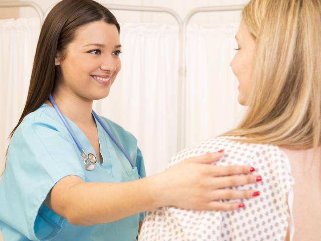 Mid-adult woman receives annual breast exam from her Latin descent gynecologist.  Breast cancer awareness concept.