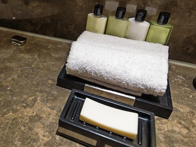 Hotel bathroom detail with soap, towel and shampoo