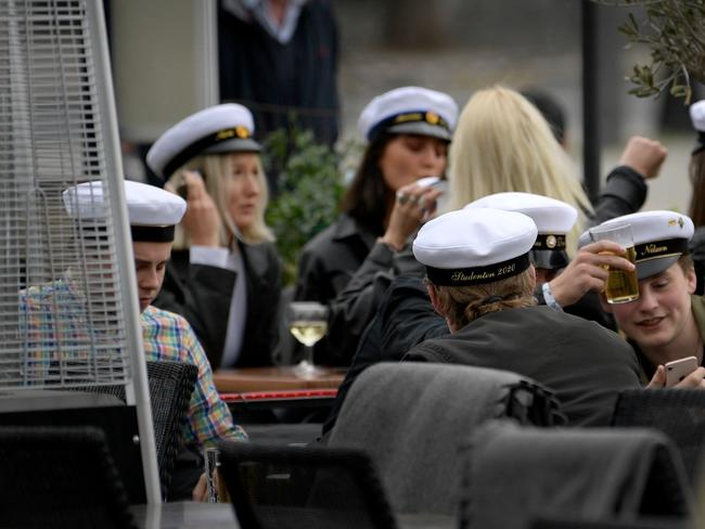 Swedish High School final year students with their characteristic caps celebrate their graduation at an outdoor restaurant in central Stockholm. Picture: Janerik Henriksson