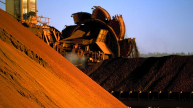 An undated handout photo made available 03 August 2005 shows a worker inspecting iron ore stockpiles at the outback location of Marandoo. Rio Tinto reports a record first-half net profit of 2.17 billion US dollars 03 August 2005. Rio Tinto posted the result, well ahead of market forecasts following a China-driven boom for resources and solid production figures. AFP PHOTO/RIO TINTO/HO (EDITORIAL USE ONLY)