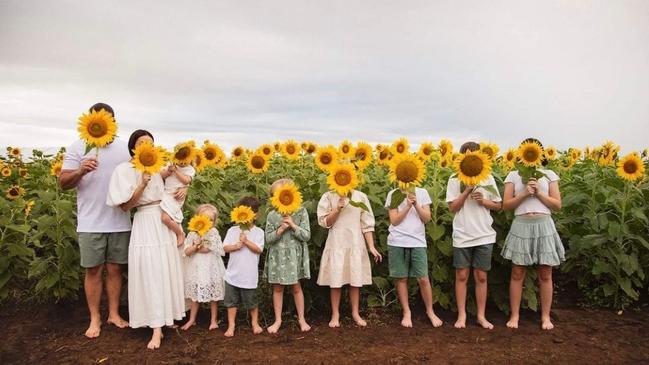 Rhys and Danielle Carroll and their eight children – including her sister Kelly Wilkinson’s three kids – pose with sunflowers to mark the anniversary of Kelly’s death. Picture: Jodie Dort Photography