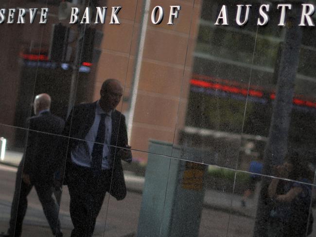 A passerby is reflected on a wall of the Reserve Bank of Australia in Sydney on February 3, 2015. Australia's central bank on February 3 lowered its key interest rate by 25 basis points to a new record low of 2.25 percent, saying after a year-and-a-half on hold the cut was justified to spur growth. AFP PHOTO / Saeed KHAN