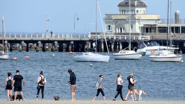 People enjoy the sunshine at St Kilda Beach on Saturday. Picture: Andrew Henshaw