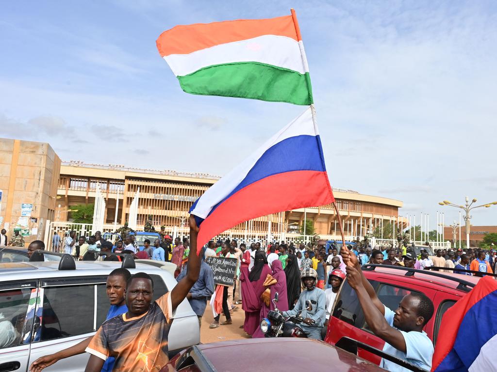 Supporters of Niger's National Council for the Safeguard of the Homeland (CNSP) wave Niger and Russian flags as they demonstrate in Niamey on August 6, 2023.