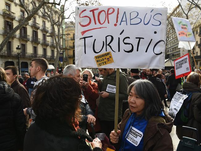 Protesters holds a sign that says “Stop the tourist abuse” during a demonstration in Barcelona in January. Photo: AFP PHOTO/LLUIS GENE