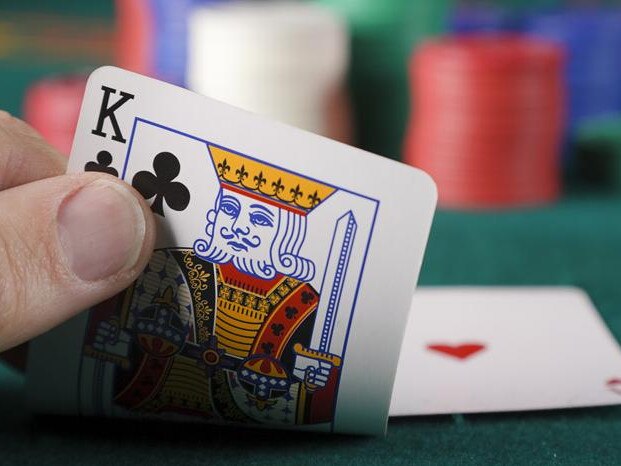 A close-up of a player's hand in a card game of blackjack.