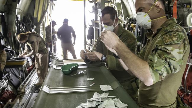 RAAF Senior Nursing Officer Squadron Leader Matt Luther prepares a dose of the AstraZeneca vaccine for administering to an ADF member aboard a C-130J Hercules aircraft in the Middle East region. Picture: Defence