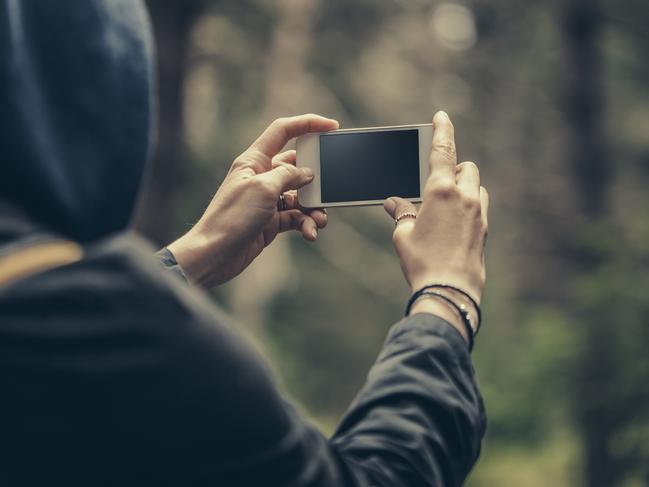 Traveler making selfie on a smart phone in the forest. Stock photo.