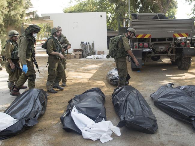 KFAR AZA, ISRAEL - OCTOBER 10: Israeli soldiers remove the bodies of civilians, who were killed days earlier in an attack by Palestinian militants on this kibbutz near the border with Gaza, on October 10, 2023 in Kfar Gaza, Israel. Israel has sealed off Gaza and conducted airstrikes on Palestinian territory after Hamas attack killed hundreds and took nearly 100 hostages. On October 7, the Palestinian militant group Hamas launched a surprise attack on Israel from Gaza by land, sea, and air, killing over 700 people and wounding more than 2000. Israeli soldiers and civilians have also been taken hostage by Hamas and moved into Gaza. The attack prompted a declaration of war by Israeli Prime Minister Benjamin Netanyahu, and ongoing retaliatory strikes by Israel on Gaza killing hundreds. (Photo by Amir Levy/Getty Images)