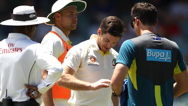 Tim Paine gets his finger checked out during the first Test against India in Adelaide.