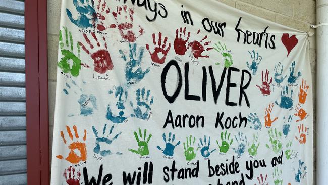 The Old Bar community shows their support for the Koch family, adding their hand prints to a large banner at the oval where Oliver died on Sunday, January 28.