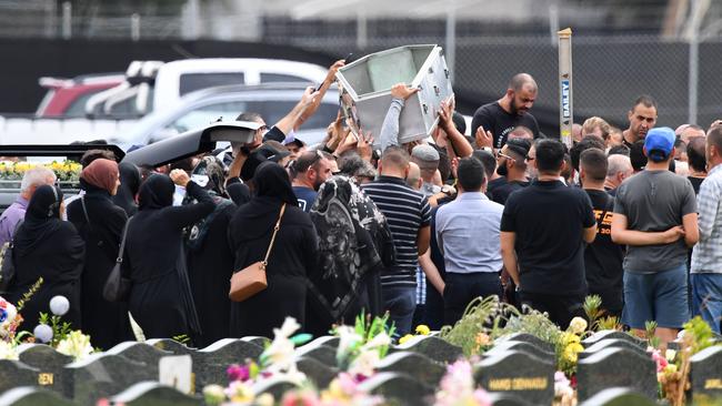 Mourners lift an empty coffin above their heads. Picture: AAP