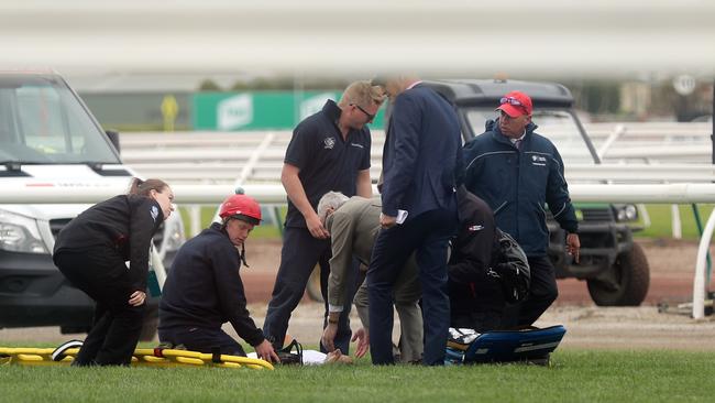 Jockey Joao Moreira is treated after falling from Regal Monarch during race four. Photo: Alex Coppel.