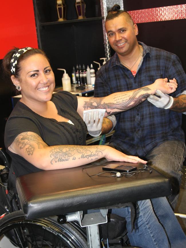 Tattoo Artist Chrash tattoos a phoenix on Heidi's arm.