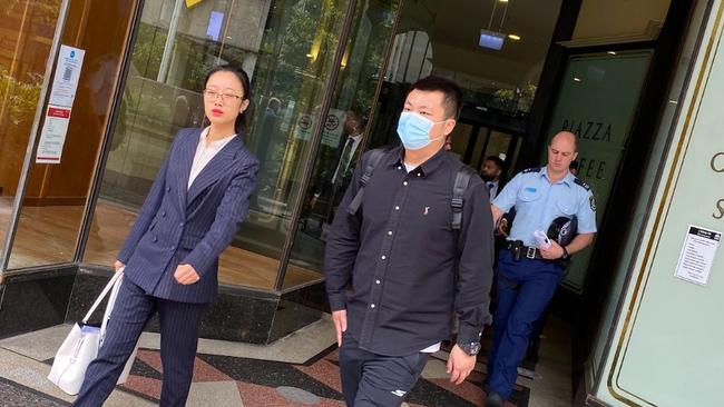 Shigang Wang pictured walking outside Downing Centre Court with his lawyer.