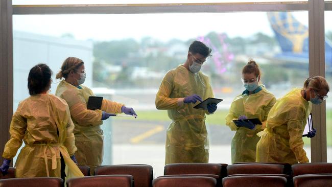 NSW Health personnel prepare for passengers arriving from Perth at Sydney airport on Monday. Picture: Jeremy Piper