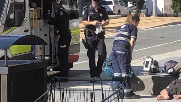 Ambulance staff help a person on Scarborough Street in Southport. Picture: Dale Anderson.