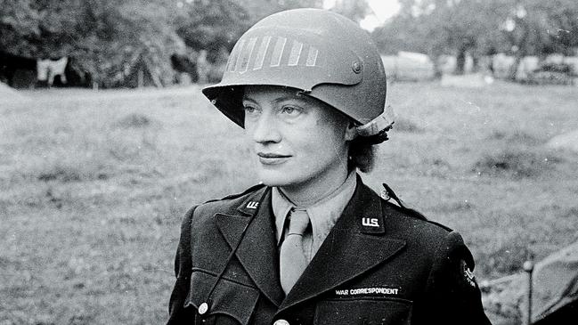 Lee Miller wearing a steel helmet specially designed for using a camera, in Normandy, 1944.