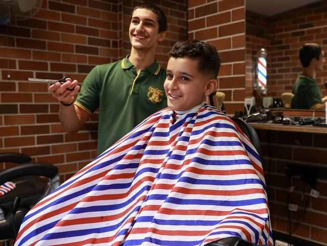 Granville’s most legendary initiative is its barber shop. Gun barber Hussein Jubouri, 17, with Safa Alassadi, 12. Picture: Justin Lloyd