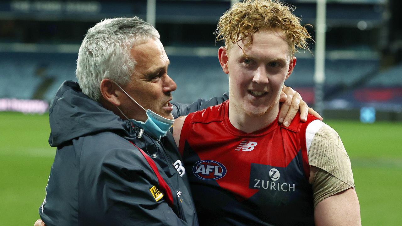 Assistant coach Mark Williams hugs Clayton Oliver after the Demons’ remarkable comeback against the Cats.